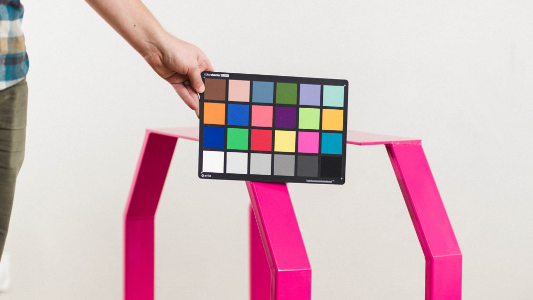 Commercial photographer utilizing a color checker chart for product photography.