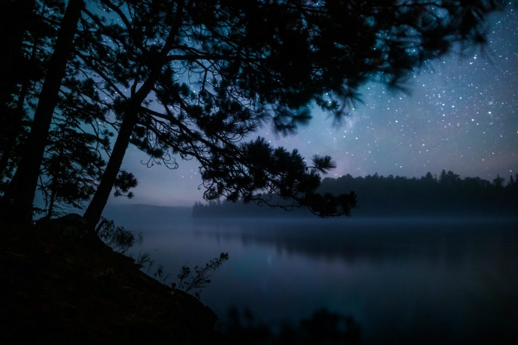Boundary Waters Canoe Area Wilderness astrophotography landscape with skyglow and stars.